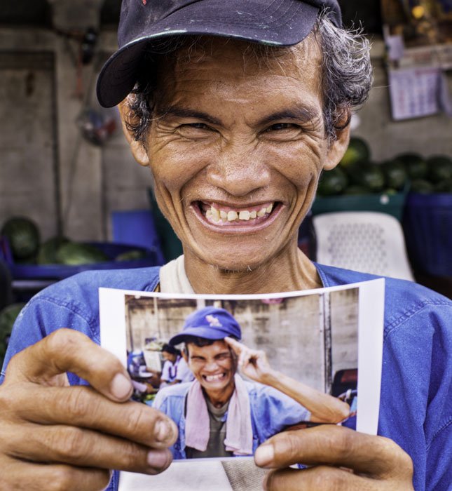 man holding a photo of himself smiling