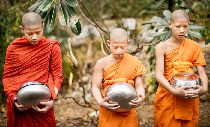 young novice monks receive alms in the morning