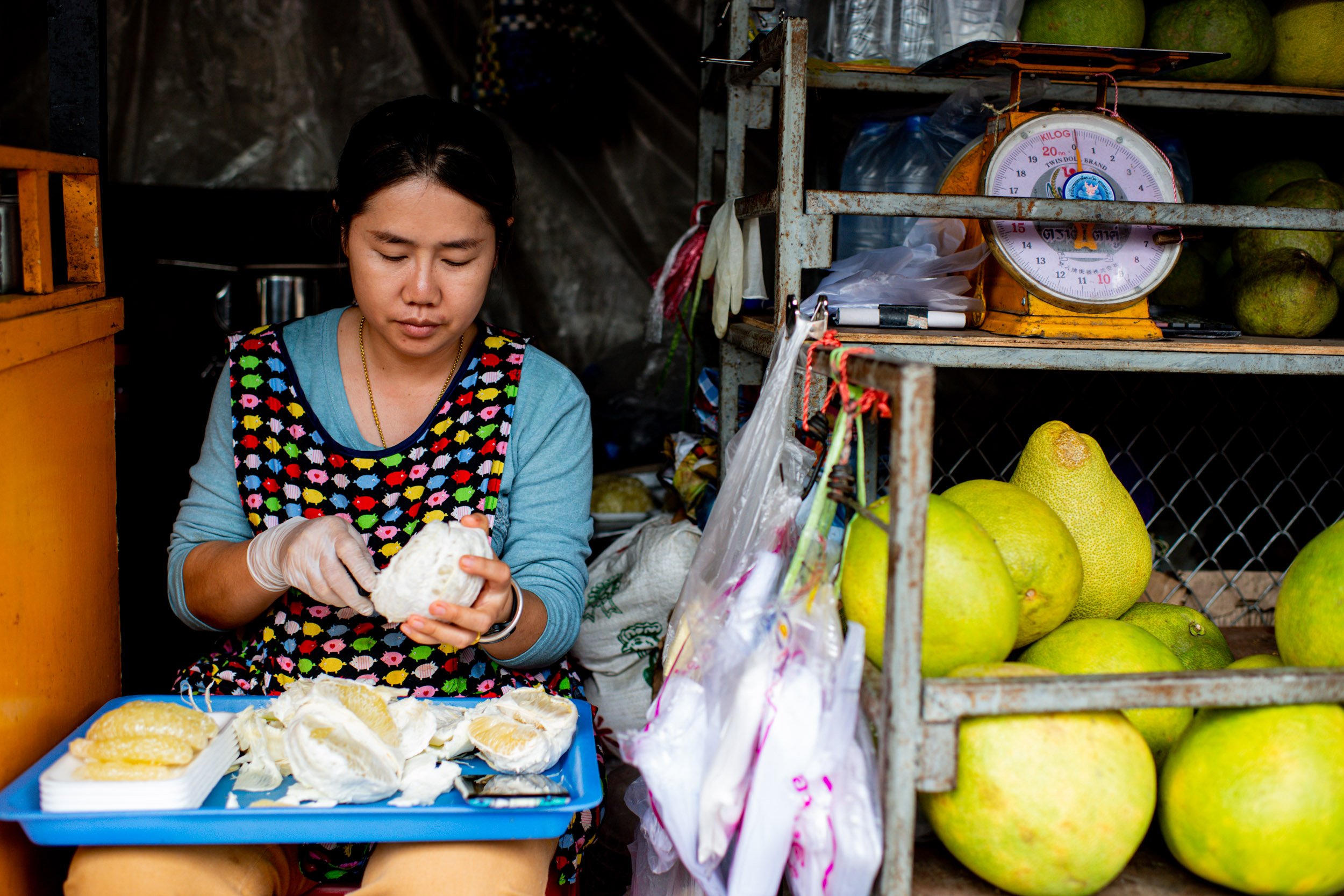 Market vendor prepares fruit to sell © Kevin Landwer-Johan